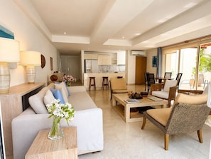 A modern living room with a sofa, coffee table, and chairs, a kitchen in the background, and a dining area with a table and chairs. - Charming 2-bedroom apartment with AC in Old City Cartagena de Indias (Cartagena de Indias)