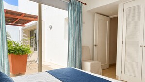 A bedroom with a bed, a chair, a door, and a view of an outdoor area. - Charming 2-bedroom apartment with AC in Old City Cartagena de Indias (Cartagena de Indias)