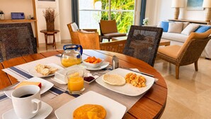 A dining area with a round table set for breakfast, including plates of food, a pitcher of orange juice, and a cup of coffee. - Charming 2-bedroom apartment with AC in Old City Cartagena de Indias (Cartagena de Indias)