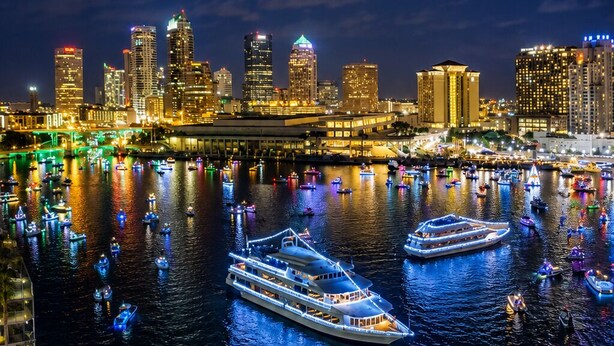 A nighttime cityscape with illuminated buildings and a marina filled with boats. - The Lincoln Luxe Studio• Private Retreat • Midtown • Downtown • Stadium  (Tampa)