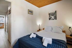 Ein Schlafzimmer mit einem Bett, Kissen, einer Nachttischlampe und einem Wandbild.