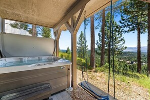 Een hottub onder een pergola met een panoramisch uitzicht op de bergen.