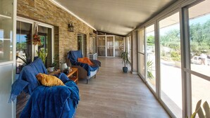 A covered porch with two sofas, a small table, and potted plants. - Gorgeous home in Dolores (Dolores)
