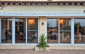 A covered patio with large sliding glass doors, a potted plant, and a tiled floor. - Gorgeous home in Dolores (Dolores)