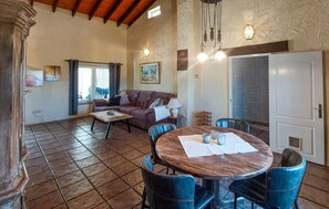 A spacious living area with a round wooden table, blue chairs, a sofa, and a dining table with chairs. - Gorgeous home in Dolores (Dolores)