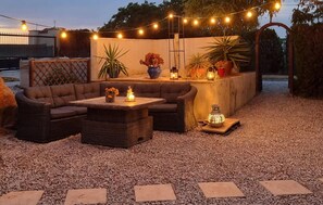 An outdoor seating area with a sofa, chairs, and a table, surrounded by potted plants and string lights. - Gorgeous home in Dolores (Dolores)