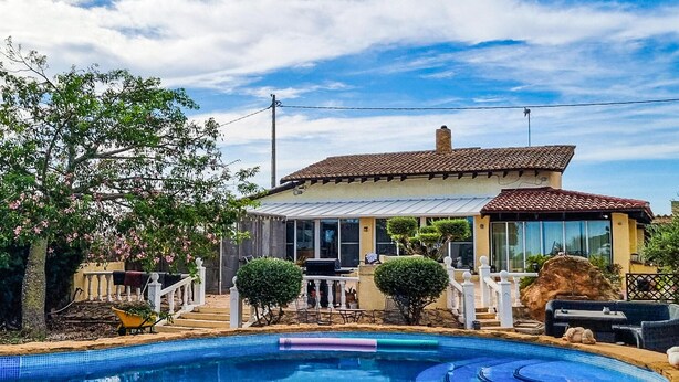 A house with a swimming pool, a covered patio, and a garden with a white fence. - Gorgeous home in Dolores (Dolores)