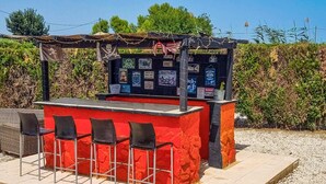 An outdoor bar with a red counter and four black chairs. - Gorgeous home in Dolores (Dolores)