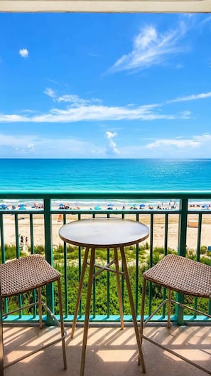 Ein Balkon mit Blick auf Strand und Meer.