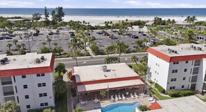 Ein Hotel mit Pool, Meerblick, Parkplatz und mehreren Gebäuden.