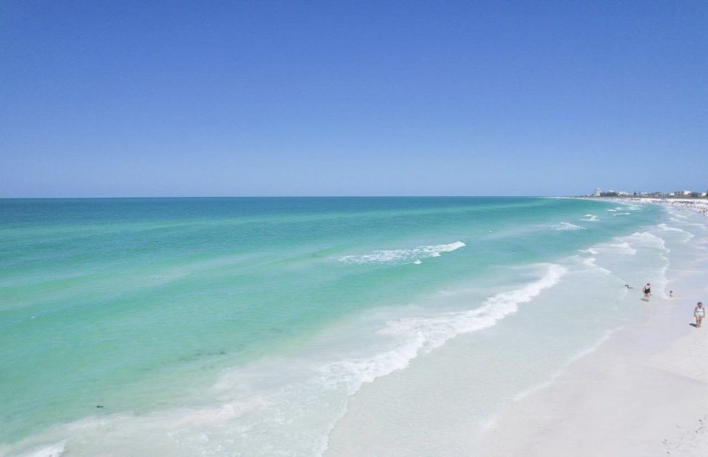 A beach with clear turquoise water and white sand.
