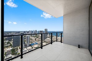 A balcony with a city view, a tiled floor, and a small black object on the floor. - E11EVEN 48th Floor | Bay Views & Rooftop Pool (Miami)
