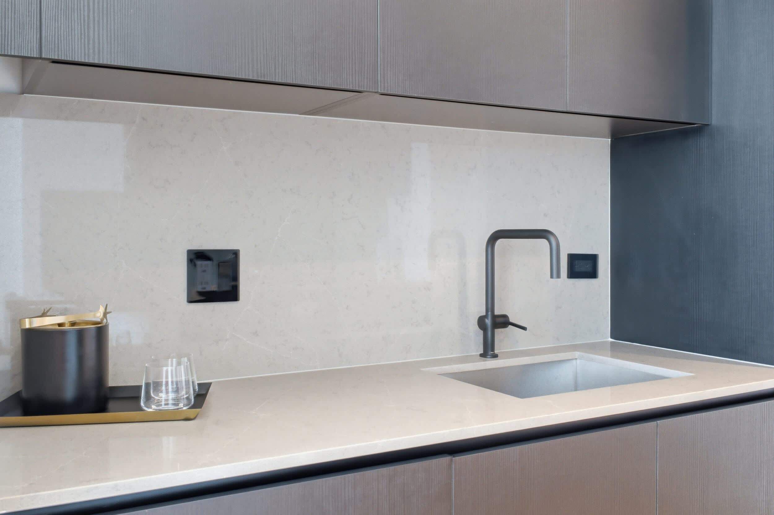 A modern kitchen with a single sink, a faucet, and a countertop.