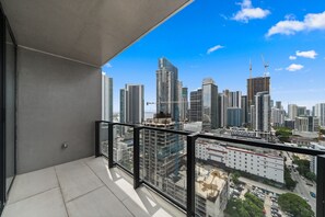 Ein Balkon mit Blick auf die Stadtlandschaft, darunter Hochhäuser und Baukräne.