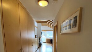A hallway with wooden flooring, a ceiling light, and a framed picture on the wall. - Luxury Moments Begin, Wallis 1077 (Wallis)