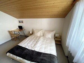 A bedroom with a bed, a desk, a chair, and a nightstand. - Luxury Moments Begin, Wallis 1077 (Wallis)