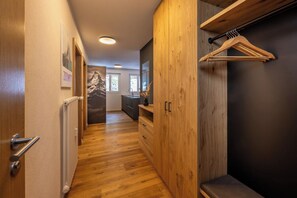 A hallway with wooden flooring, a radiator, a wooden wardrobe, and a coat rack. - Breathtaking Luxury Stay, Wallis 1079 (Wallis)