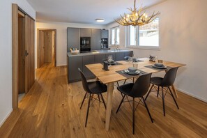 A modern kitchen with a dining area, wooden flooring, and a chandelier. - Breathtaking Luxury Stay, Wallis 1079 (Wallis)