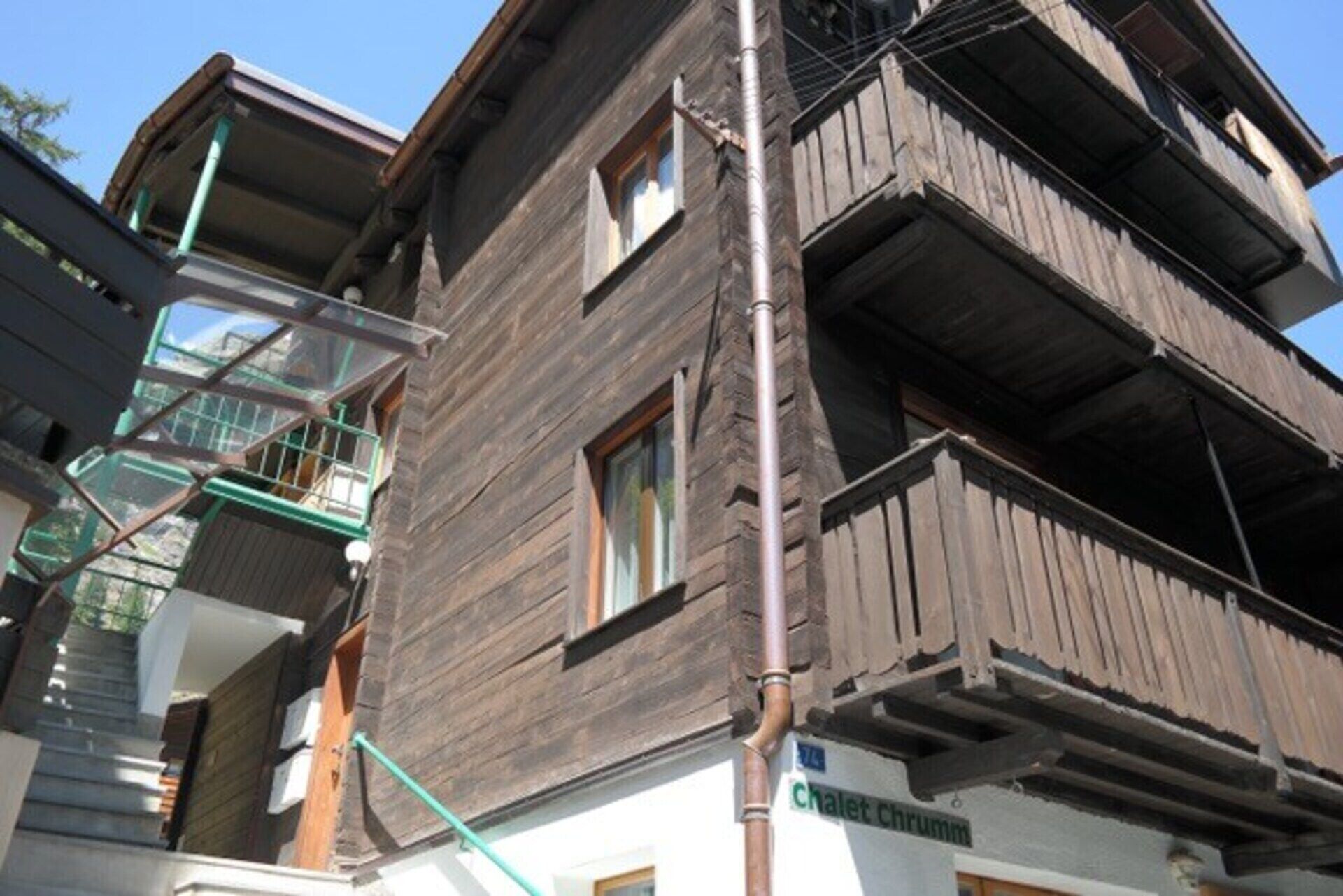Un immeuble à plusieurs étages doté de balcons extérieurs et d’un escalier apparent.