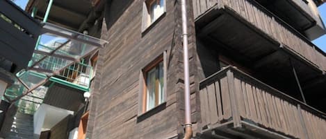 Un edificio de varios pisos con balcones exteriores y una escalera visible.