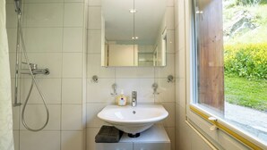 A bathroom with a white sink, a mirror, and a shower. - Where Comfort Meets Luxury, Wallis 1081 (Wallis)