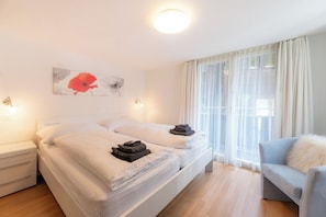 A hotel room with a bed, a chair, and a window with curtains. - Where Comfort Meets Luxury, Wallis 1081 (Wallis)