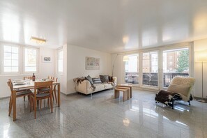 A spacious living area with a dining table, sofa, and a chair. - Chic Alpine Living, Wallis 1073 (Wallis)