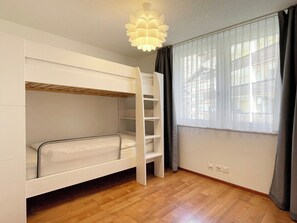 A bunk bed room with a ladder, a window with curtains, and a light fixture. - Your Cozy Luxury Escape, Wallis 1074 (Wallis)