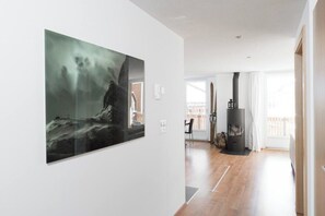 A spacious room with a large painting on the wall, a wooden floor, and a fireplace. - Your Cozy Luxury Escape, Wallis 1074 (Wallis)