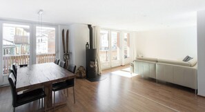 A spacious living area with a wooden dining table, a sofa, and a fireplace. - Your Cozy Luxury Escape, Wallis 1074 (Wallis)