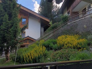 A two-story building with a wooden staircase leading to a balcony. - Mountain Bliss Awaits, Wallis 1075 (Wallis)