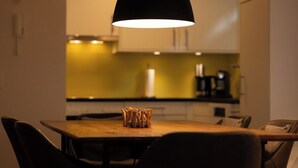 Ruokailutila, jossa on pöytä, tuolit ja riippuvalaisin.