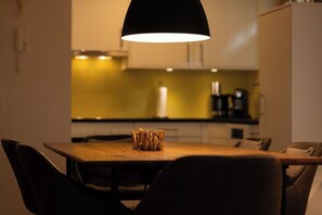 Ein Essbereich mit Tisch, Stühlen und einer Pendelleuchte.