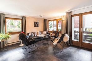 Ein modernes Wohnzimmer mit einer Sofagarnitur, einem Couchtisch und einem Kamin.