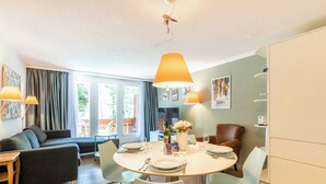 Ein modernes Wohnzimmer mit Essbereich, ausgestattet mit einer Couch, einem Esstisch und Stühlen.