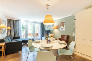 Ein modernes Wohnzimmer mit Essbereich, ausgestattet mit einer Couch, einem Esstisch und Stühlen.