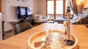 Ett matbord i trä med en ljusstake, ett glas och en burk.