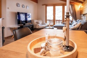 A wooden dining table with a candle holder, a glass, and a jar. - Luxury Alpine Retreat, Wallis 1071 (Wallis)