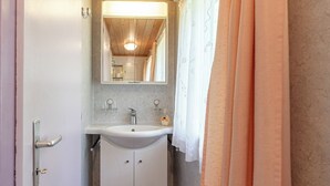 Un baño con lavabo, espejo y cortina de ducha.