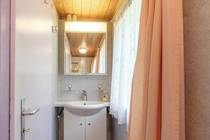 Ein Badezimmer mit Waschbecken, Spiegel und Duschvorhang.