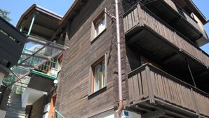 Un edificio de varios pisos con balcones exteriores y una escalera visible.