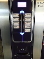 Una cafetera con pantalla digital y varias opciones de bebidas.