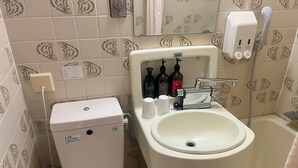 Une salle de bain avec des toilettes, un lavabo et une baignoire.