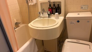 A bathroom with a sink, toilet, and bathtub. There are toiletries on the wall.