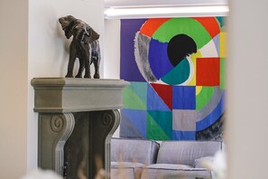 A sculpture on a pedestal, a colorful abstract painting, and a couch in a room. - Villa Dei Sassi, Villa by the sea with pool (Ancona)