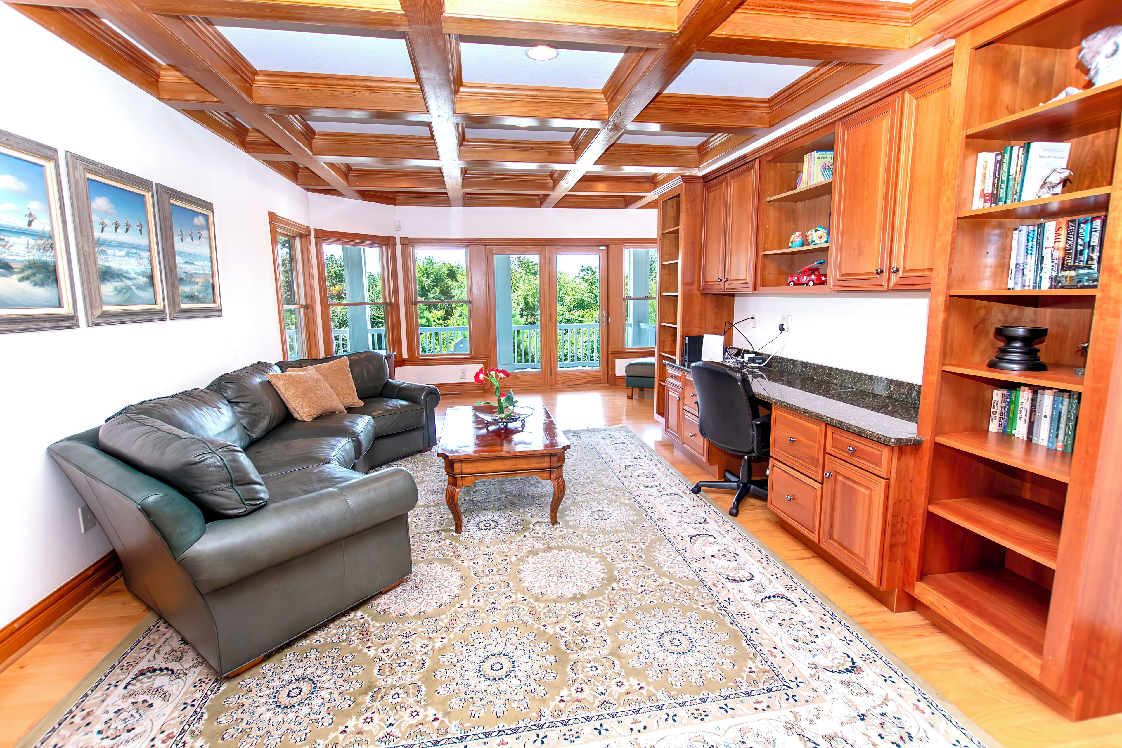 A living room with a leather sofa, a coffee table, and a patterned rug.