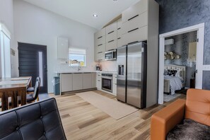 Eine moderne Küche mit einem großen Kühlschrank, einer Mikrowelle und einer Kaffeemaschine.