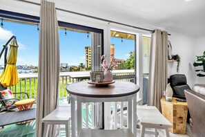 A balcony with a round table, chairs, and a view of the cityscape. - Sandpiper Cover 2020 - Near Beach - Sleeps 4 (Destin)