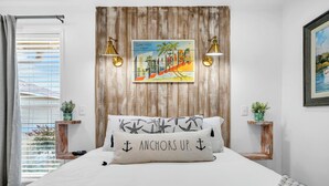 A bedroom with a bed, two bedside tables, a window with blinds, a wooden headboard, and a painting. - Sandpiper Cover 2020 - Near Beach - Sleeps 4 (Destin)