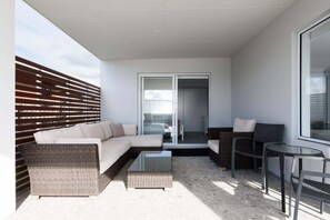 A modern outdoor living area with a sofa, chairs, and a table. - Wake Up to Stunning Tamar Valley Views (Riverside)